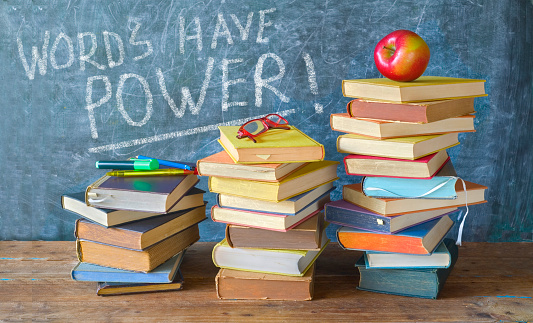 Stack of books and caption on black board Words have power, back to school,education reading,learning concept